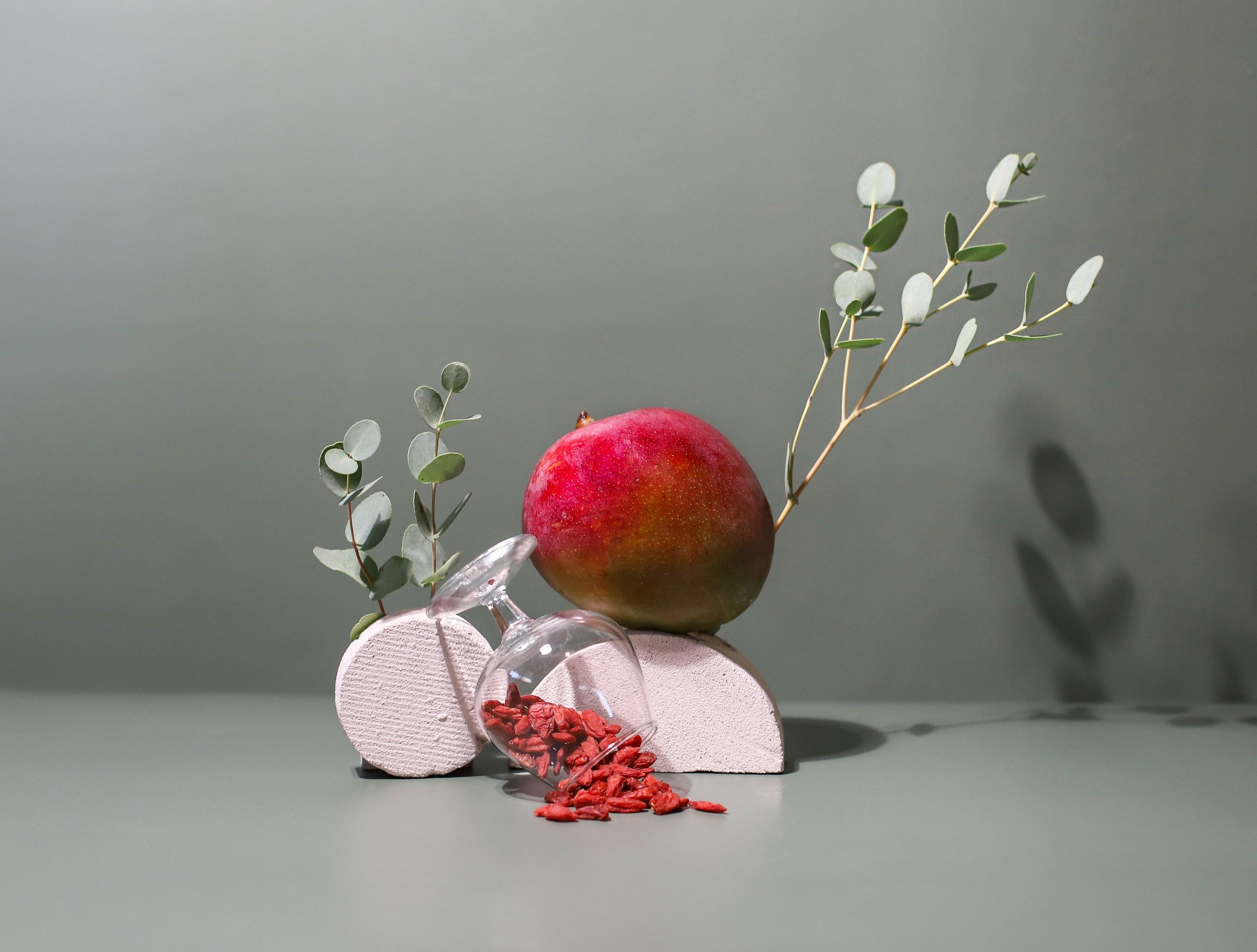 Goji Berries spilling out of a glass, mango and Eucalyptus