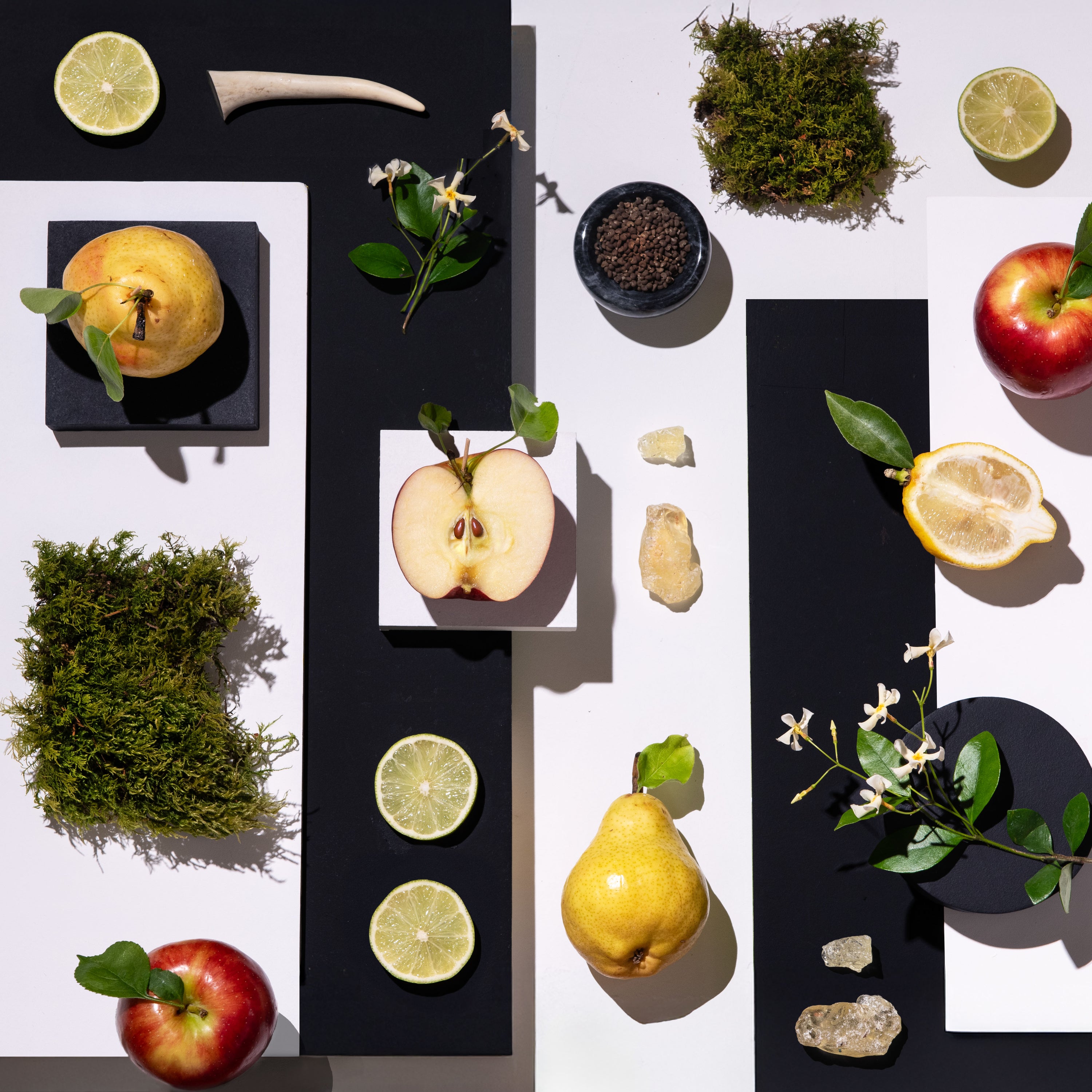 Arrangement of fruits, vegetables, and decorative elements on a black and white background