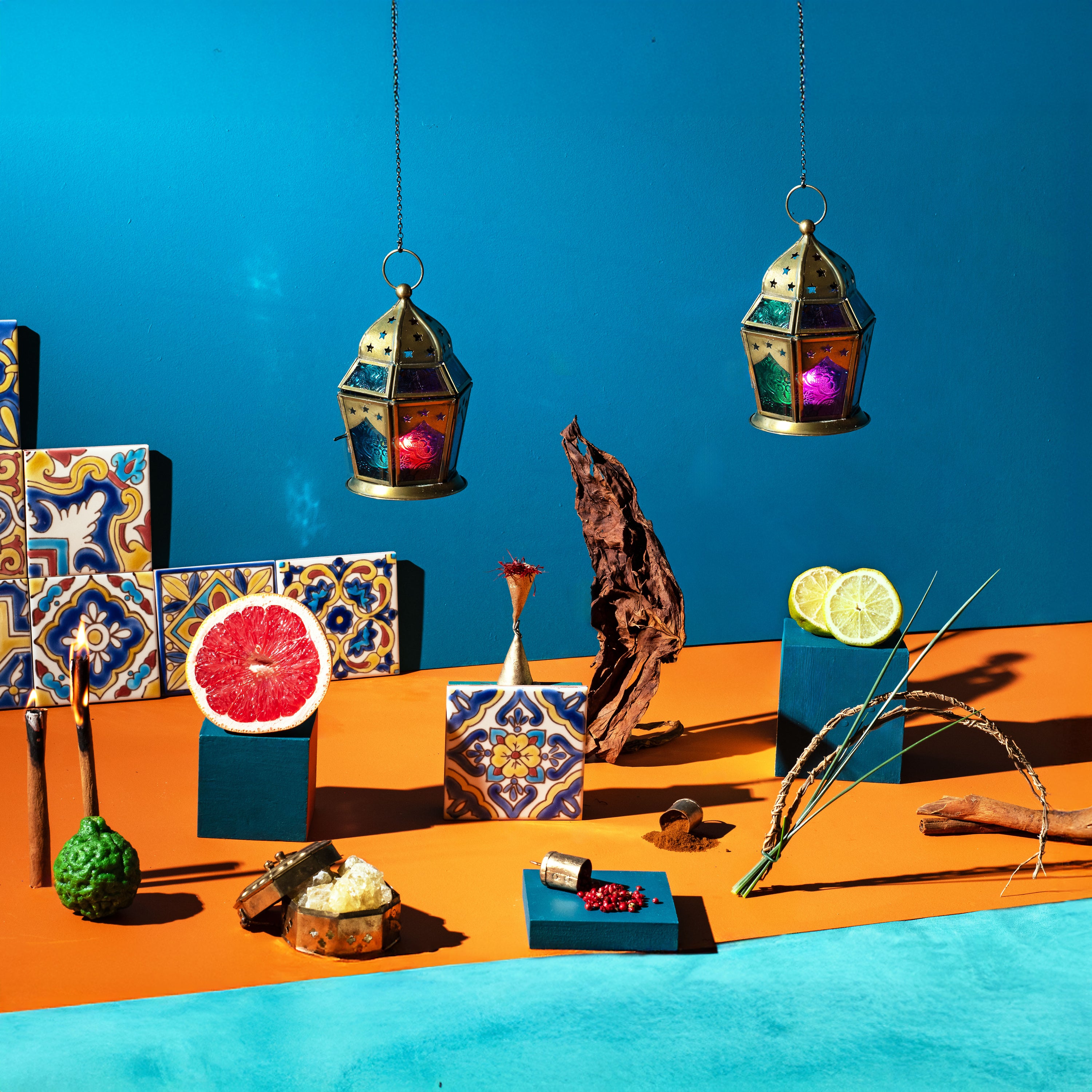 Decorative scene with colorful lanterns, tiles, and fruit on a blue and orange background