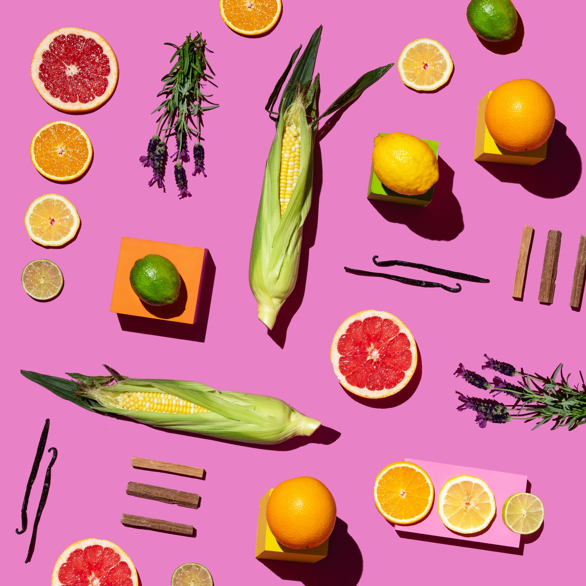 Assorted fruits, vegetables, and herbs on a pink background