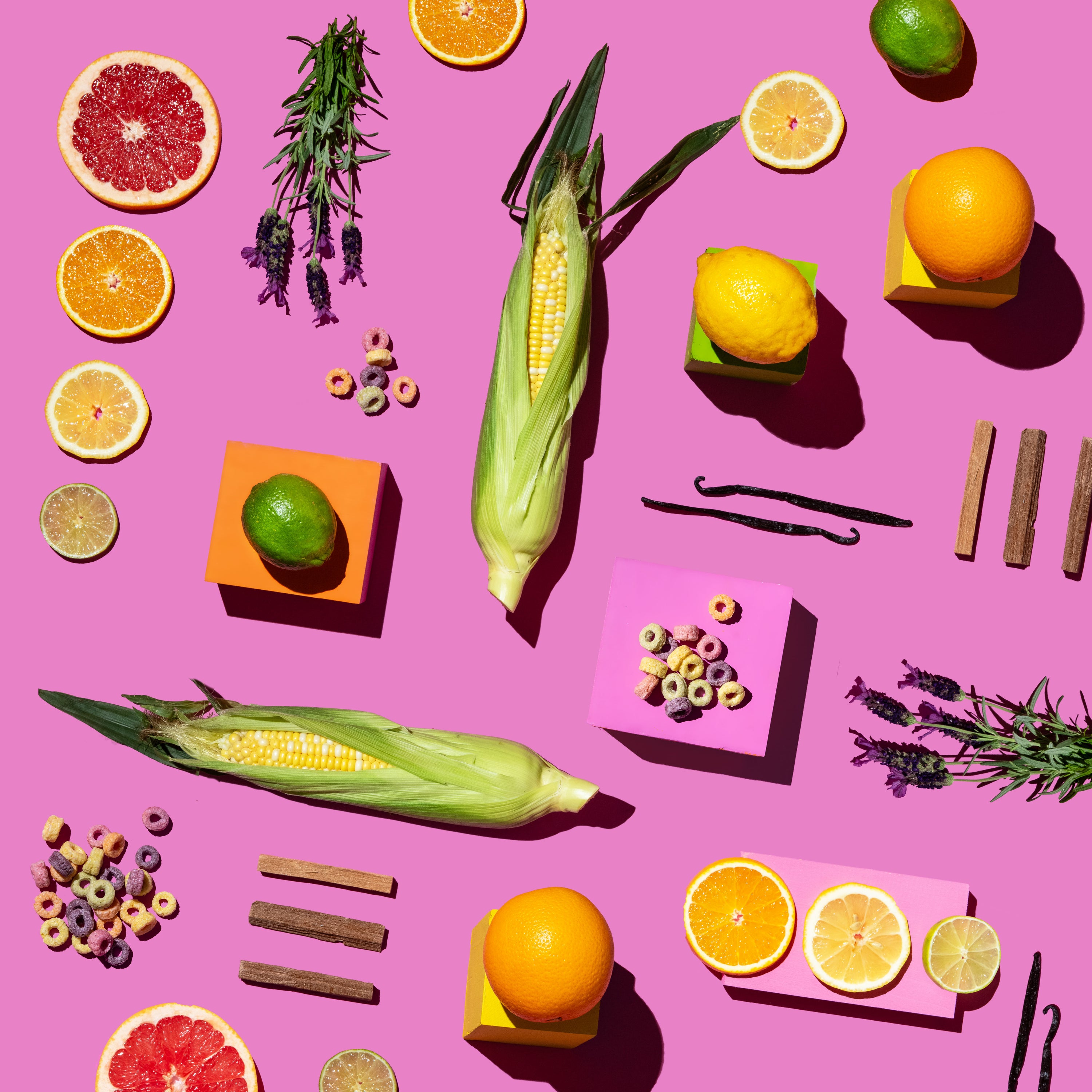 Assorted fruits, vegetables, and herbs on a pink background