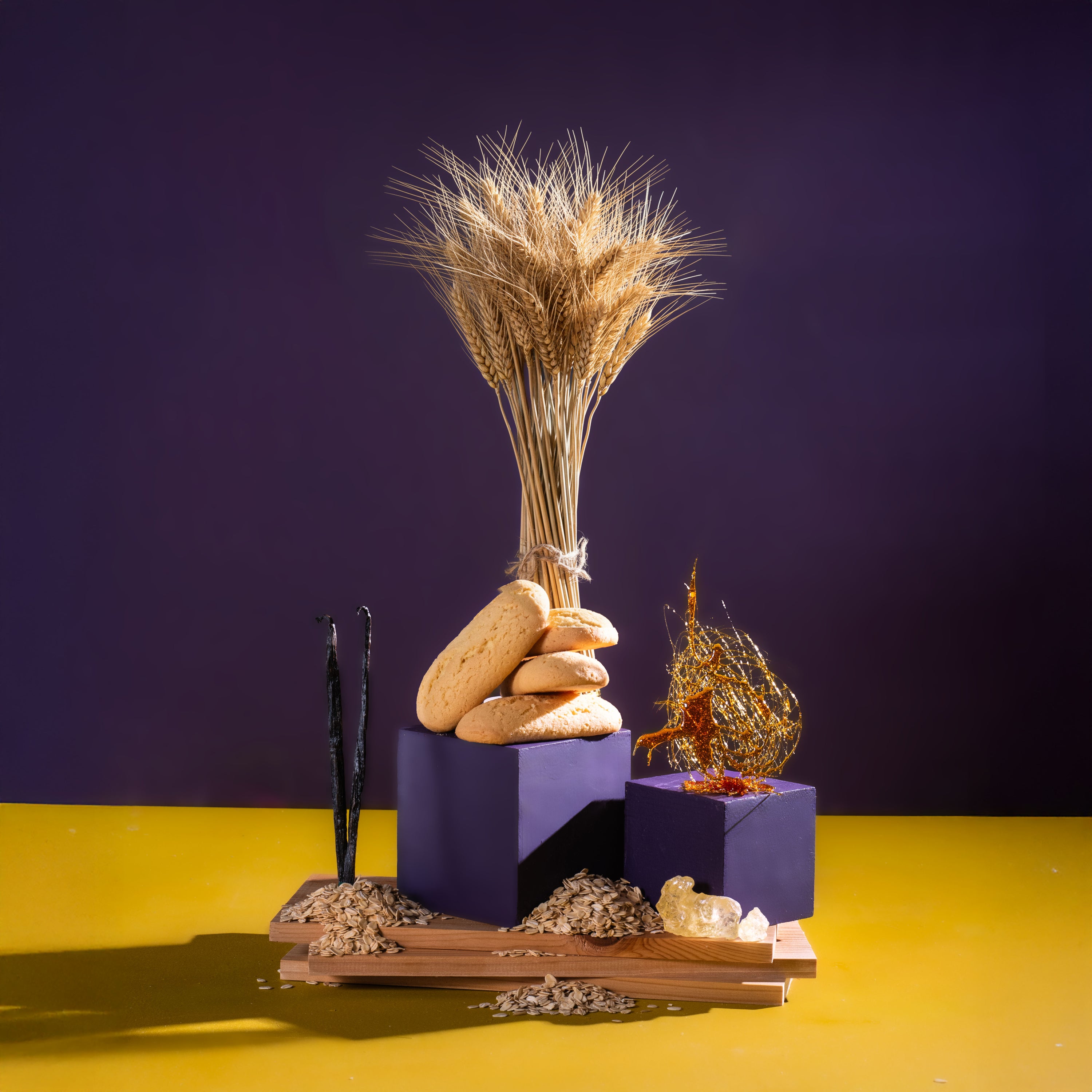 Decorative arrangement with wheat, stones, and candles on a purple and yellow background