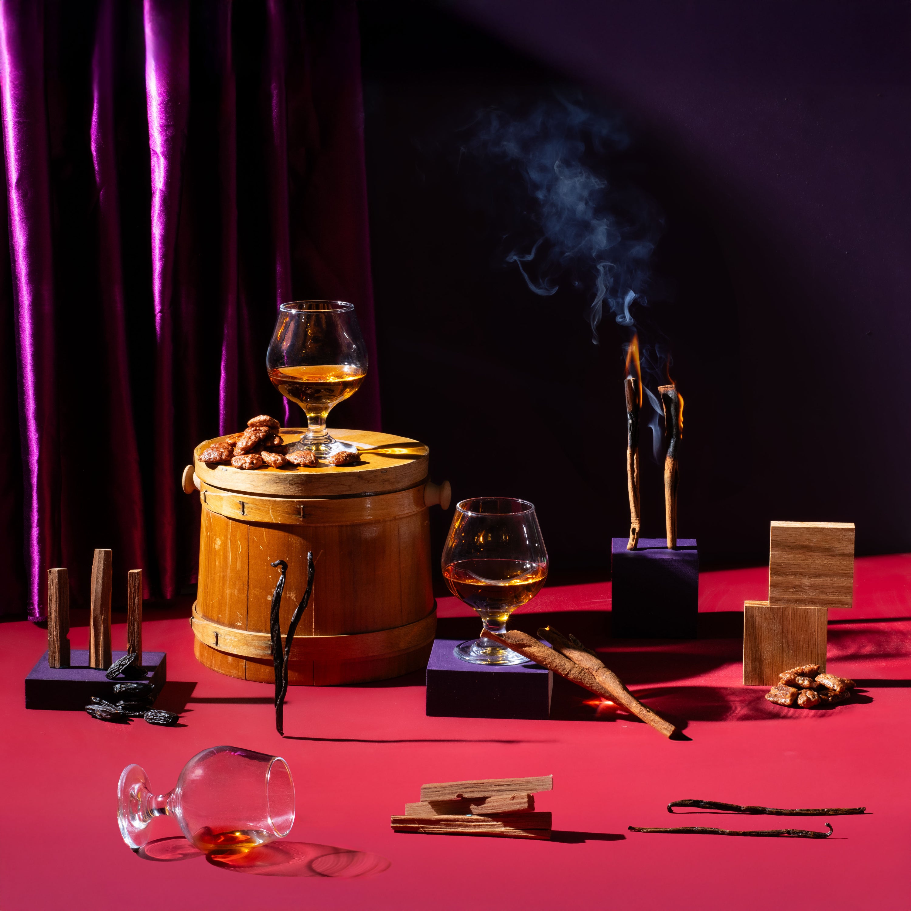 Two glasses of whiskey on a wooden barrel with smoking background