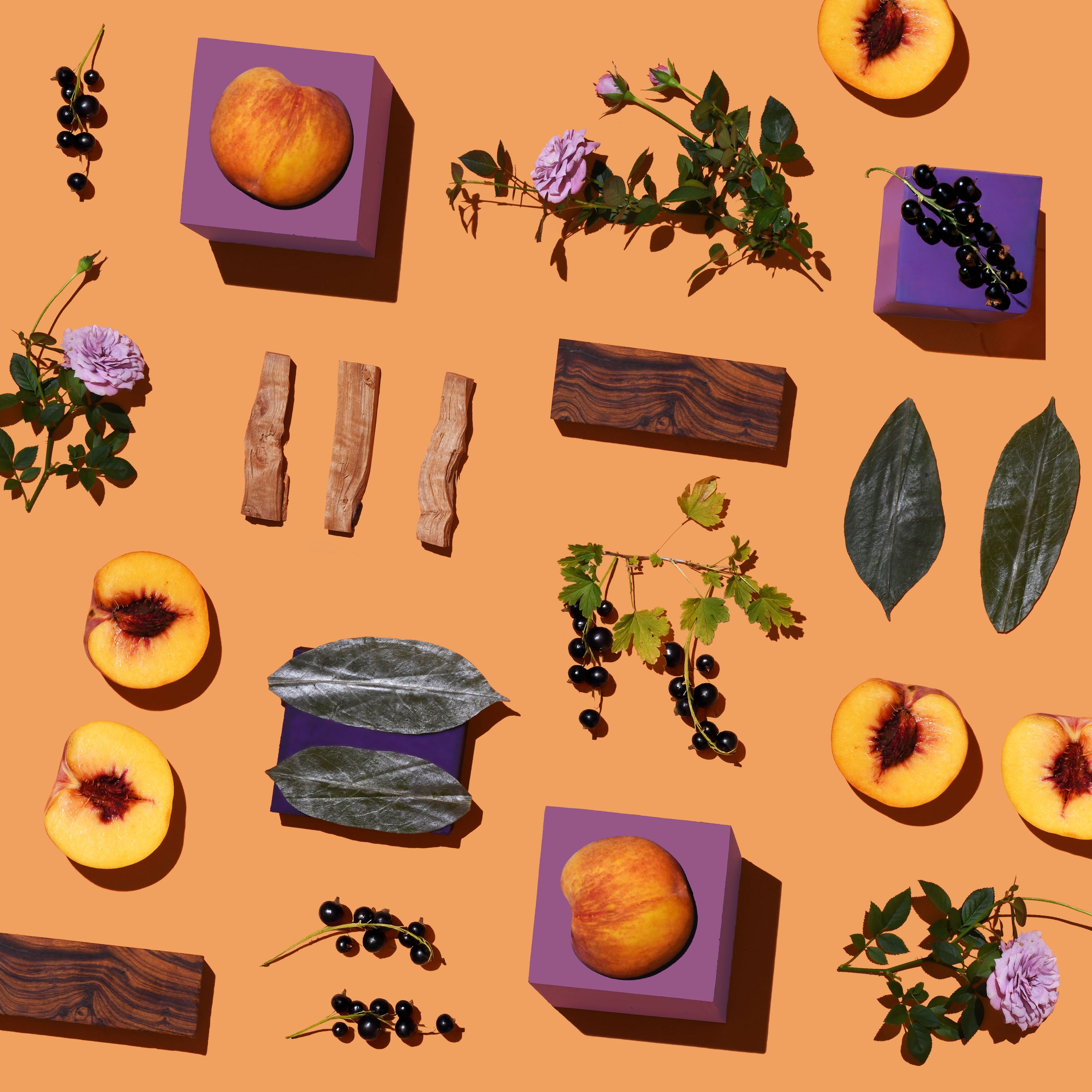 Peaches, leaves, flowers, and wooden blocks on an orange background