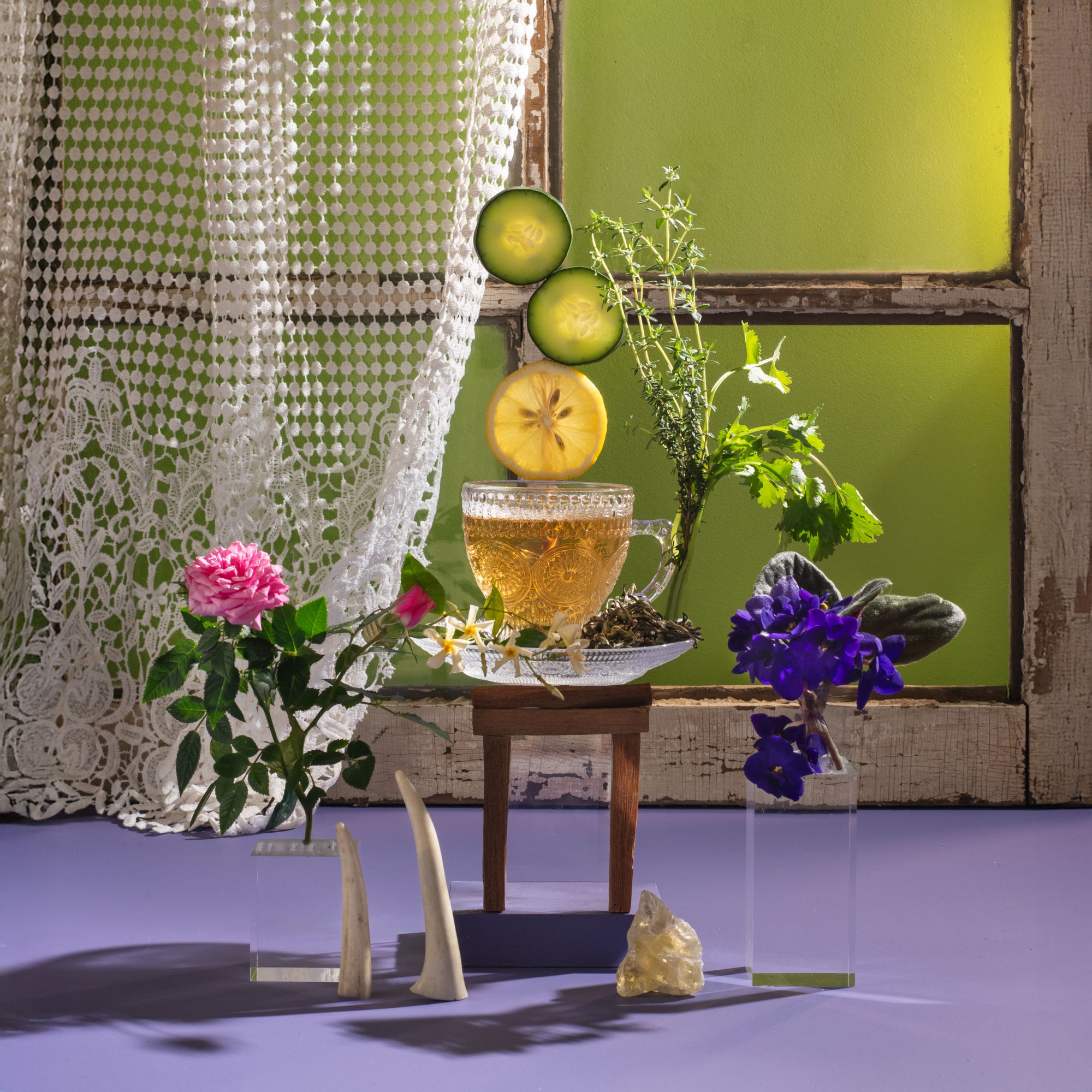 Tea cup with lemon slices, flowers, and decorative elements on a table.