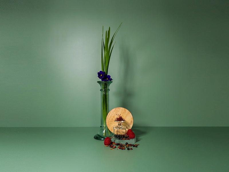Violets high in a vase with saffron on a green background