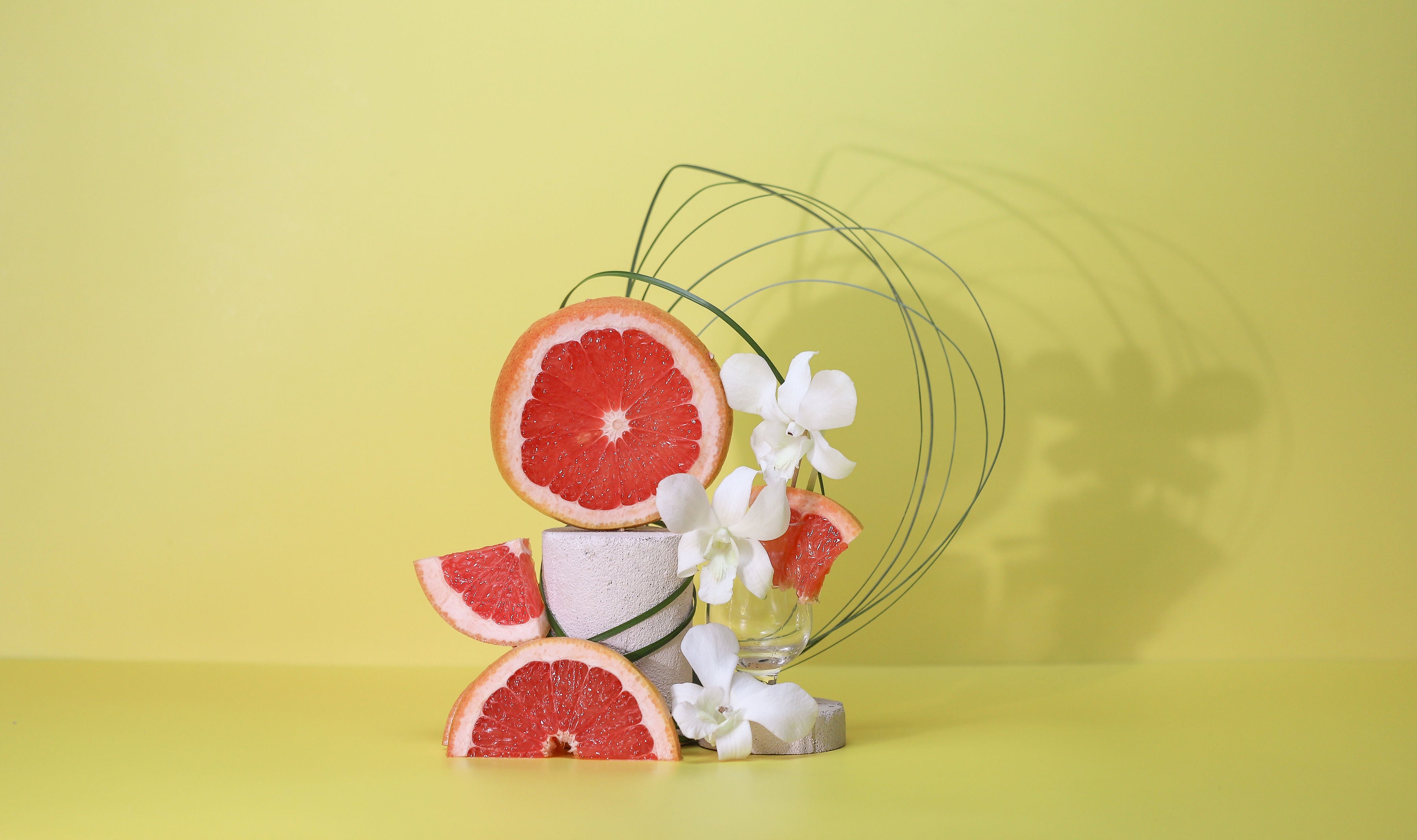 Grapefruit stacked with white flowers and long grass